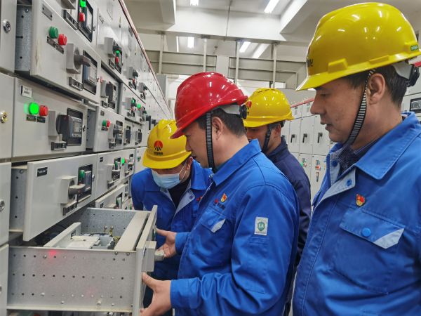 3月16日，對標(biāo)交流現(xiàn)場，大家圍在一起對配電室開關(guān)柜查找差距與優(yōu)勢.jpg