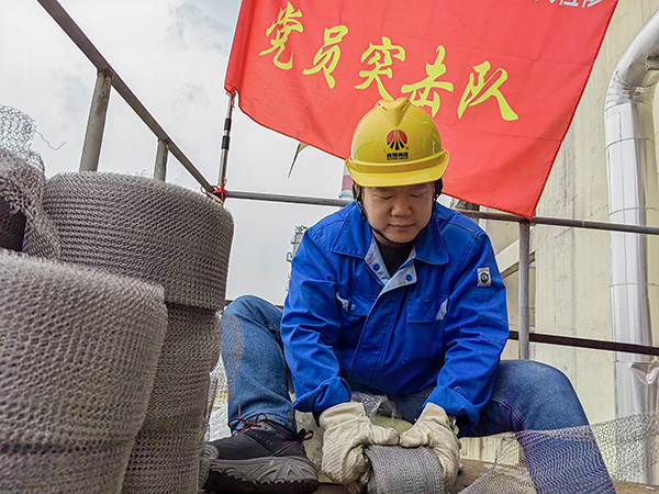 5月10日中午，在動力車間三期工藝除氧器平臺上，黨員突擊隊隊長李鑫正在纏繞新填料.jpg
