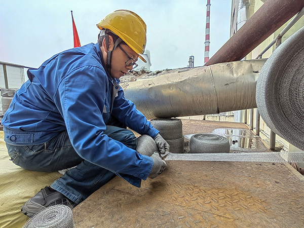 5月10日中午，在動力車間三期工藝除氧器平臺上，黨員突擊隊隊員劉瑞斌正在纏繞新填料.jpg
