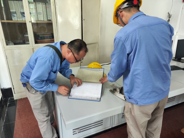 師帶徒，8月21日，老師傅王益在一期控制室為新員工胡含朗講解儀表設(shè)備圖紙.jpg